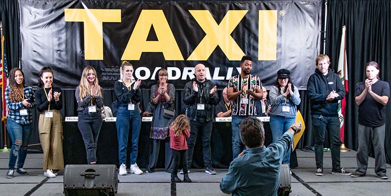 Michael called the staff up to the stage to take a bow and get a well-deserved standing ovation at the end of the Rally. From the left, they are: Angel Maradiaga, Angela Mukul, Ariana Cubillos Voegler, Briagha McTavish, Debra Laskow, Eric Anderson, Isaac Williams, Liz Cohen, Matt Hutchison, and Tom Stillwagon. We have no idea who that kid is, and how she got on stage ;-).