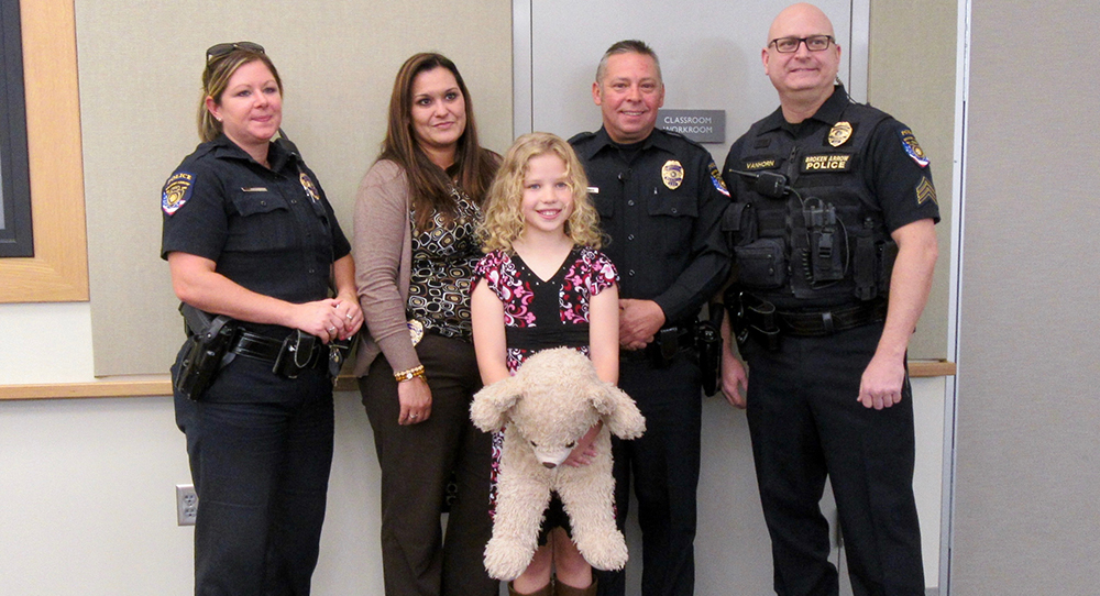 Gwenevere and the police offers who helped save her. This shot was taken in 2015, and Gwenevere brought the bear that one of the officers brought her while she was recovering in the hospital. 