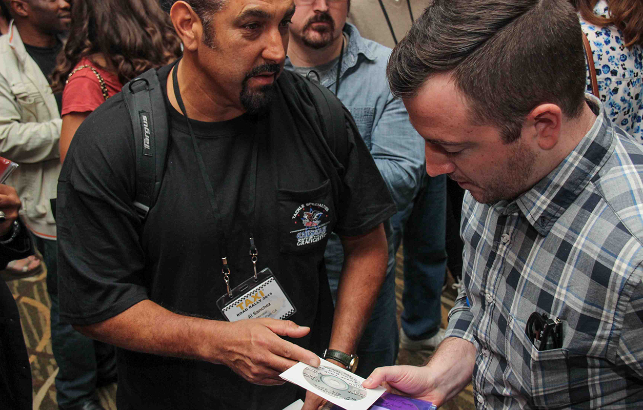 Hollywood Trailer Music Supervisor Naaman Snell takes a look at a CD given to him by TAXI Member Al Sanchez.